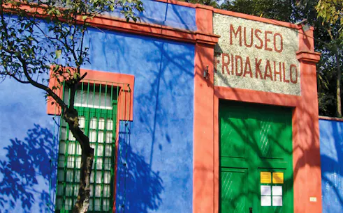 Frida Kahlo Museum entrance with blue walls and green door in Mexico City.