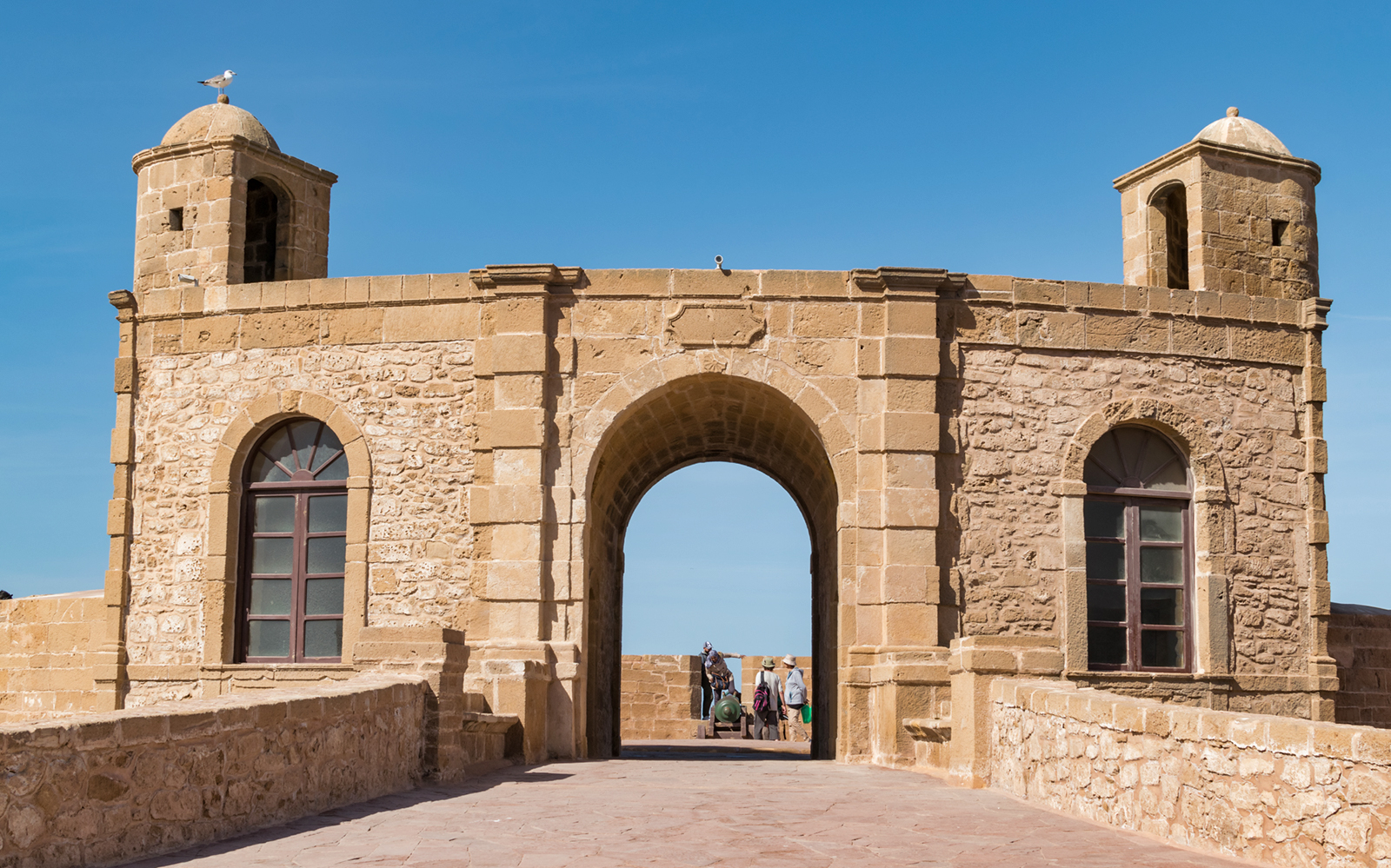 Essaouira city gate with tourists, part of the Medina visit on a day trip from Marrakesh.