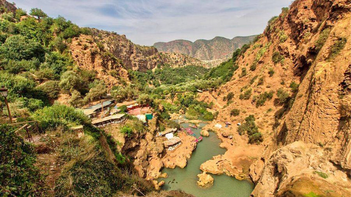 Ouzoud Waterfalls canyon view with lush greenery and river, seen on a day tour from Marrakesh.
