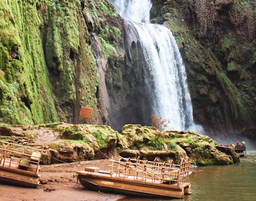 Boats near Ouzoud Waterfalls with lush greenery, part of a day tour from Marrakesh.