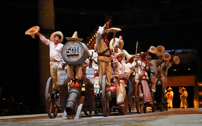 Performers in traditional attire on stage during Xcaret Park night show, Mexico.