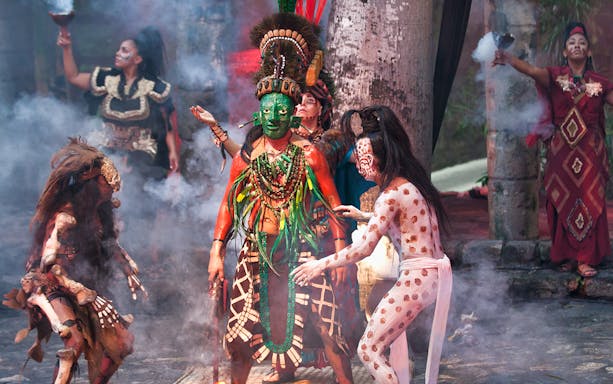 Traditional Mayan performance at Xcaret Park with dancers in ceremonial attire.