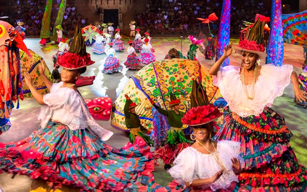 Traditional dancers performing at Xcaret night show in colorful costumes, Mexico.