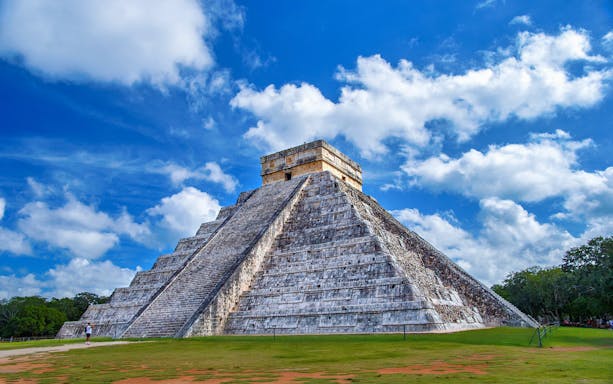 Chichen Itza pyramid under blue sky on guided tour in Mexico.