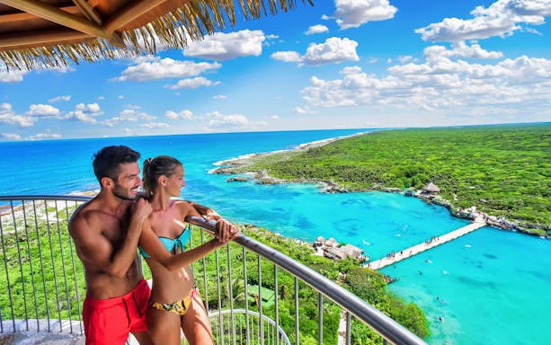 Couple enjoying ocean view from observation deck at Xel Há Park, Mexico.