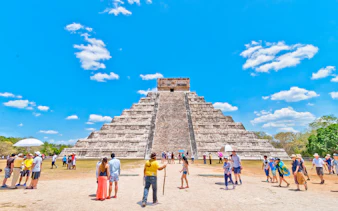 Tourists exploring the Pyramid of Kukulcán at Chichen Itza, Mexico.