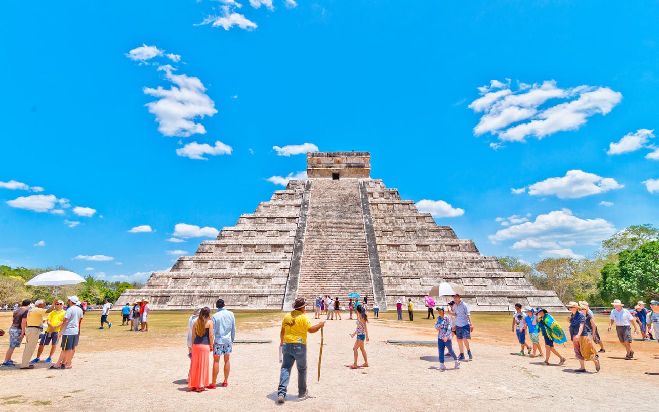 Tourists exploring the Pyramid of Kukulcán at Chichen Itza, Mexico.