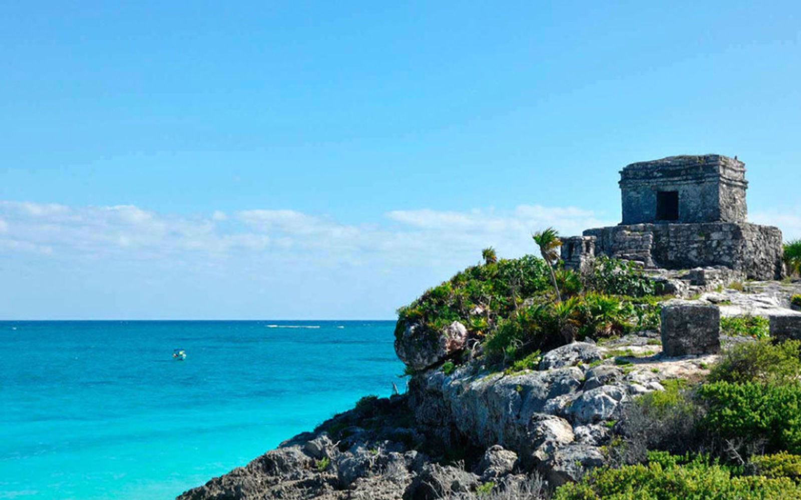 Tulum ruins overlooking the Caribbean Sea on a sunny day.