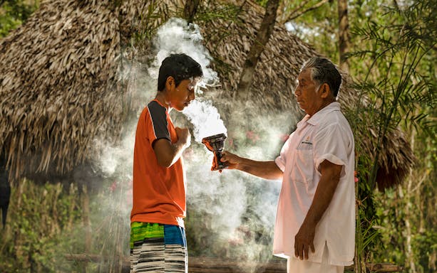 Mayan elder performing a traditional ritual with incense in Tulum & Coba Maya Village.