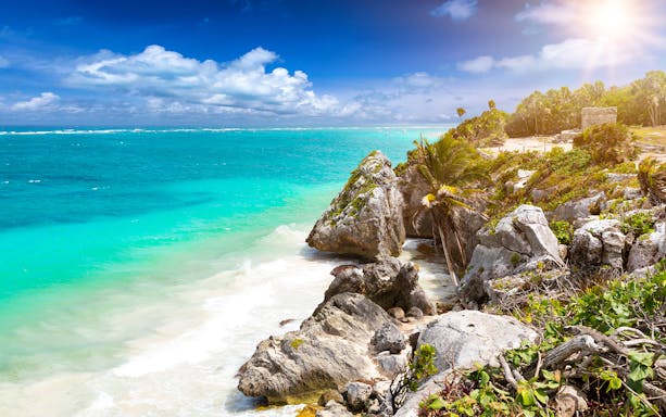 Tulum Ruins overlooking the Caribbean Sea on a sunny day.