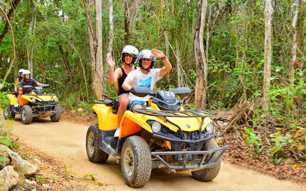 ATV riders on a forest trail during Cancun Snorkel & Zipline Xtreme Tour.