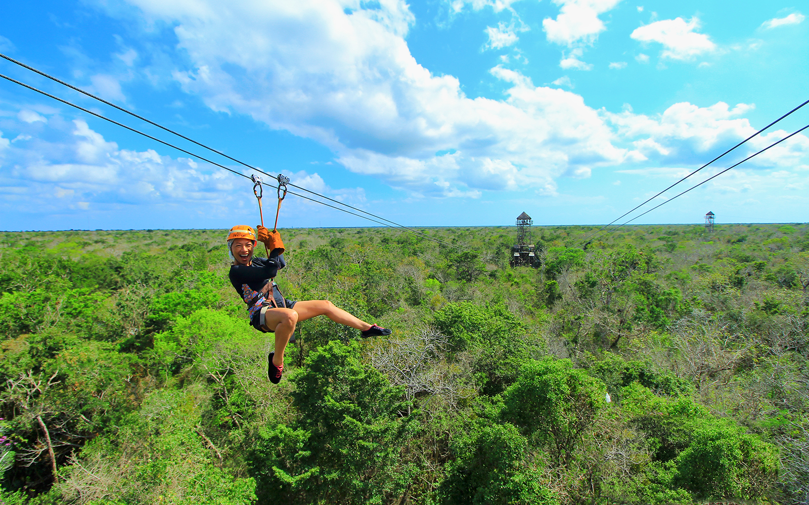 Person ziplining over lush forest in Cancun during Snorkel & Zipline Xtreme Tour.
