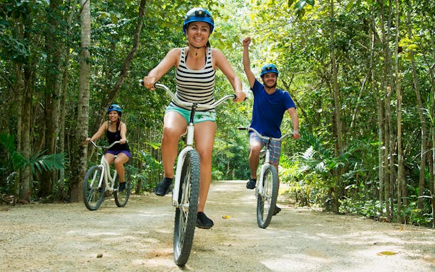Cyclists enjoying a forest trail at Rio Secreto Reserve.