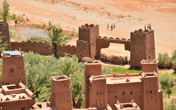 Kasbah Aït Benhaddou with tourists walking, Ouarzazate private tour from Marrakesh.