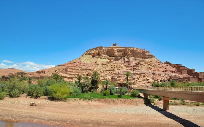 Kasbah Aït Benhaddou with bridge and greenery, Ouarzazate Private Tour from Marrakesh.