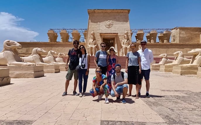 Group at Atlas Film Studios entrance, Ouarzazate, with Egyptian-themed statues.