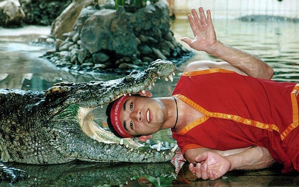 Performer with crocodile at Samphran Elephant Ground & Zoo, Thailand.