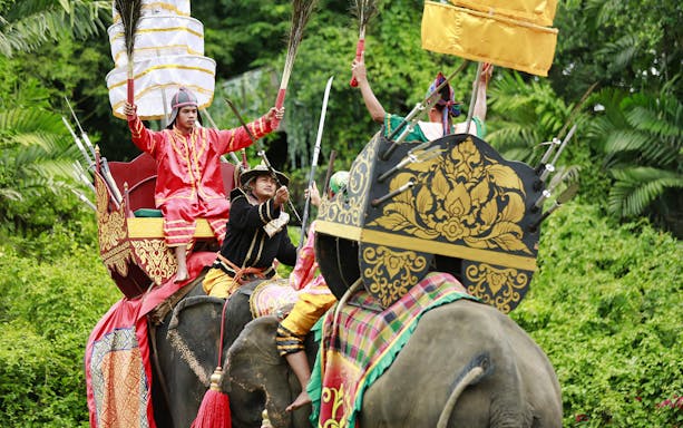 Elephants with riders in traditional costumes at Samphran Elephant Ground & Zoo.