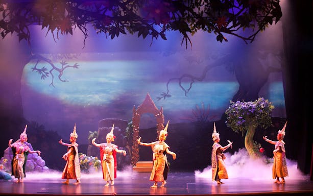 Khon Thai dancers performing at Sala Chalermkrung Royal Theater with ornate costumes and traditional backdrop.