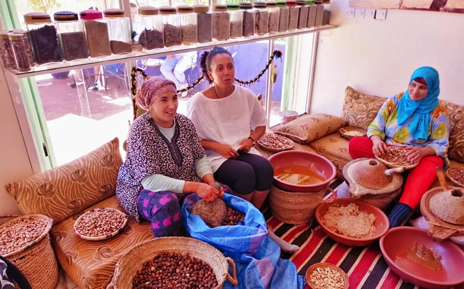 Women preparing argan oil in a traditional setting during the Ourika Valley tour near Marrakesh.