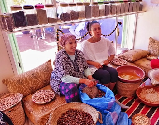Women preparing argan oil in a traditional setting during the Ourika Valley tour near Marrakesh.