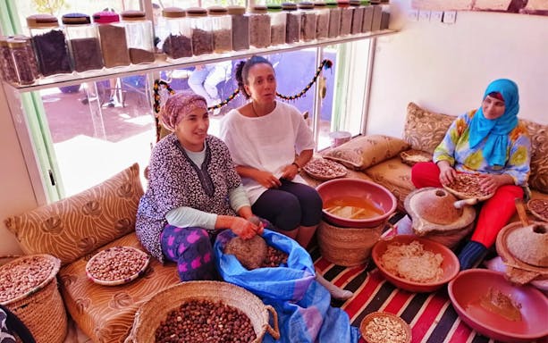 Women preparing argan oil in a traditional setting during the Ourika Valley tour near Marrakesh.