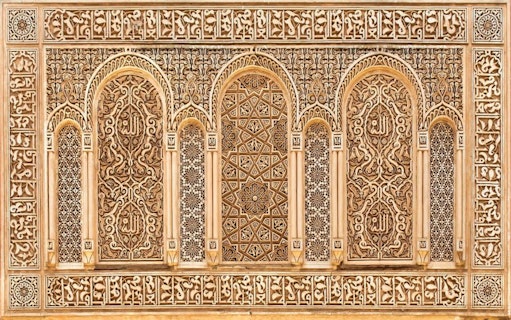 Intricate Islamic architectural details on a wall in Marrakesh, featuring ornate carvings and geometric patterns.
