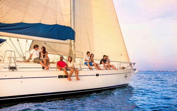 Group enjoying a sunset sailing tour on a yacht in Cabo San Lucas.