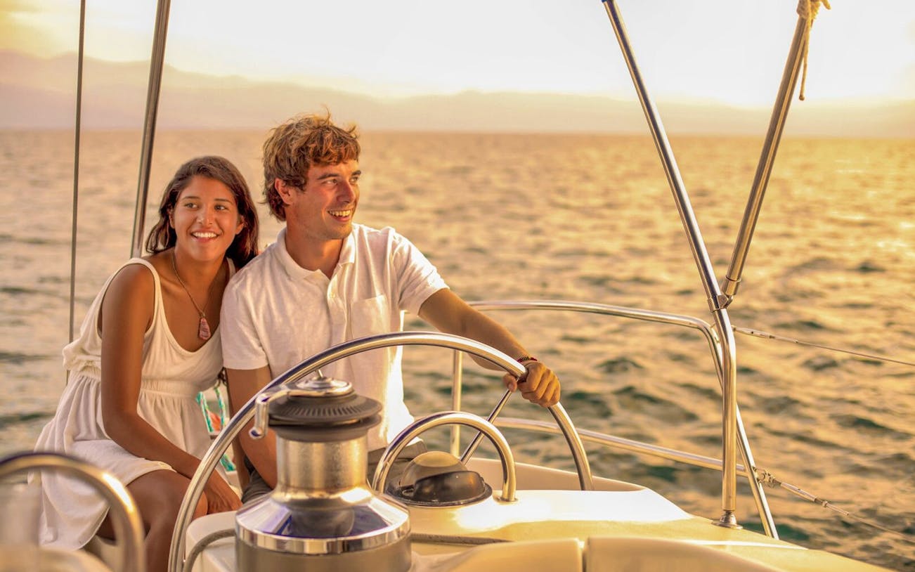 Couple enjoying a sunset sailing tour in Cabo San Lucas.