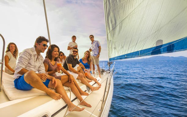 Group enjoying a sailing tour at sunset in Cabo San Lucas.