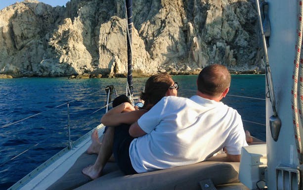 Cabo San Lucas sunset dinner cruise with tequila tasting, featuring a boat on serene waters under a vibrant sky