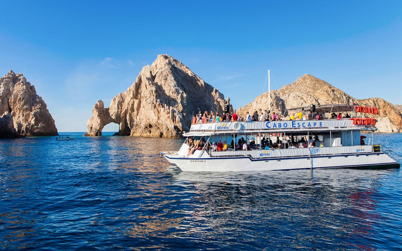 Cruise boat near El Arco rock formation in Cabo San Lucas during sunset dinner tour.