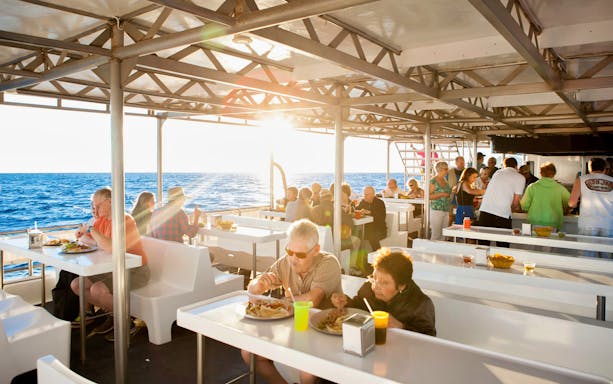 Guests enjoying dinner on a sunset cruise in Cabo San Lucas.