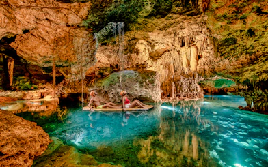 Visitors rafting through a cave with stalactites at Xplor Park, Mexico.