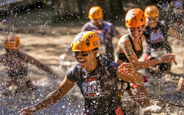 Visitors enjoying a water activity at Xplor Park with helmets and splashing water.