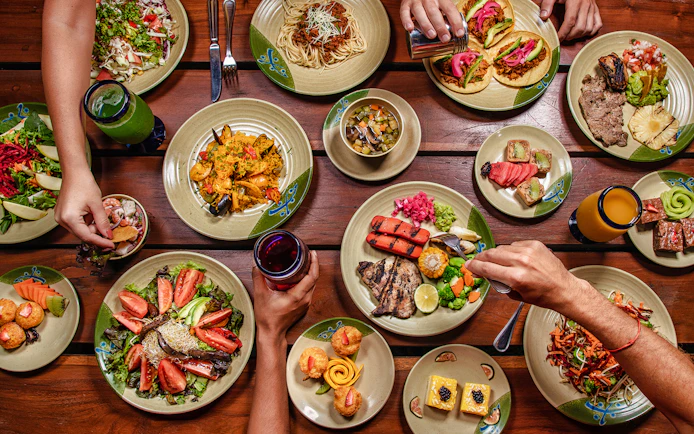 Assorted Mexican dishes on a wooden table at Xplor Park dining area.