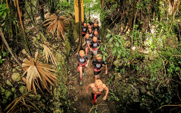 Visitors hiking through lush jungle at Xplor Fuego Park.