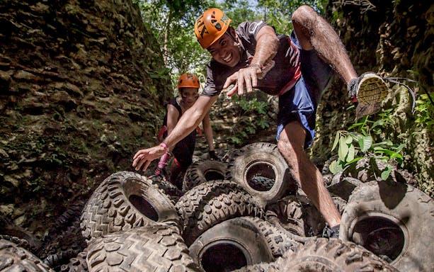 Visitors navigating a tire obstacle course at Xplor Fuego Park.