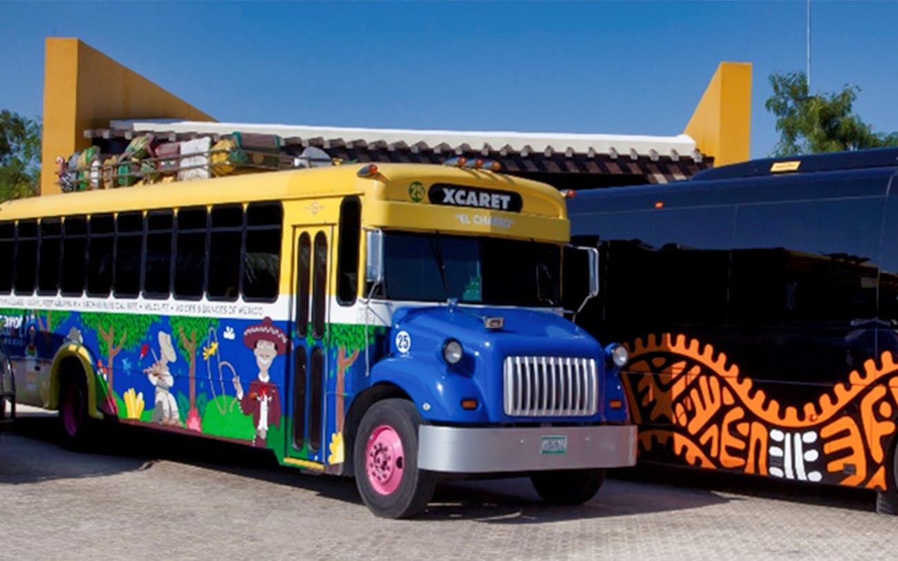 Colorful Xcaret bus for Xavage Park 1-day admission with official transportation.