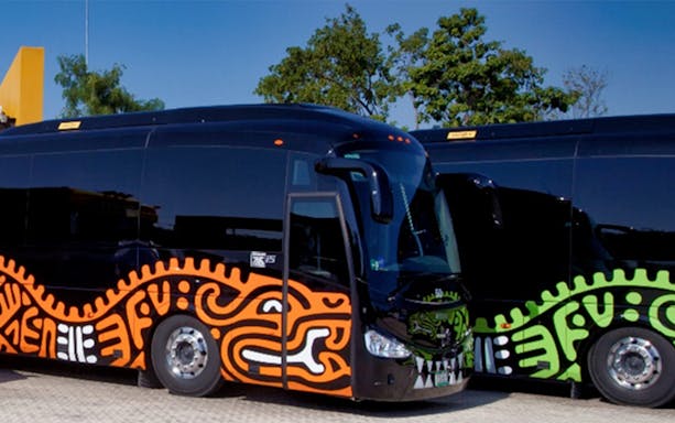 Official transportation bus for Xavage Park 1-Day Admission, featuring vibrant tribal designs.