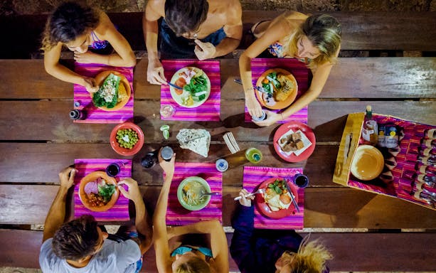 Dining experience at Xenotes Park with guests enjoying lunch at a wooden table.