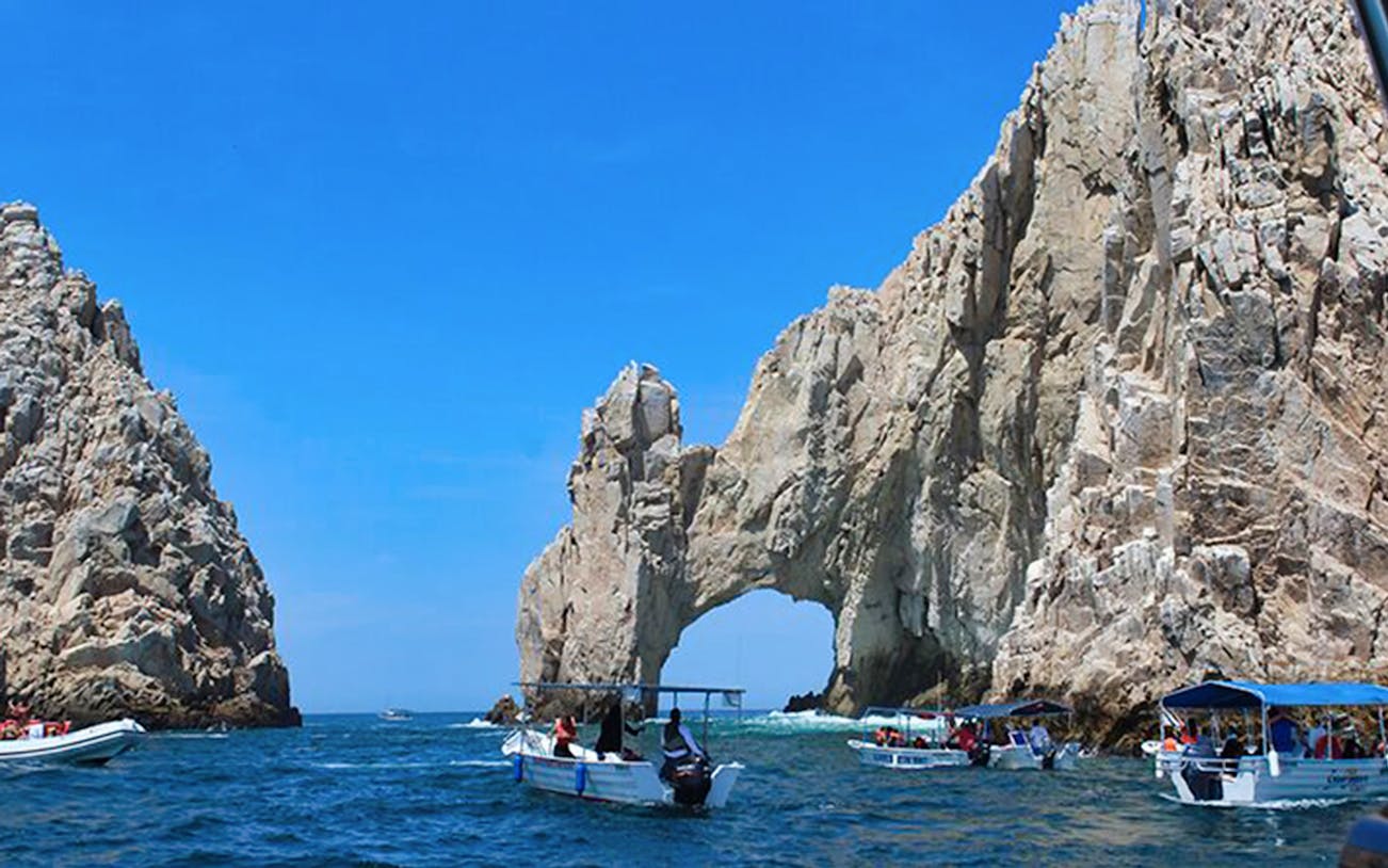 Boats near El Arco rock formation in Cabo San Lucas during snorkeling tour.