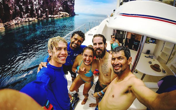 Group of friends on a boat during Cabo San Lucas Sea of Cortez snorkeling adventure.