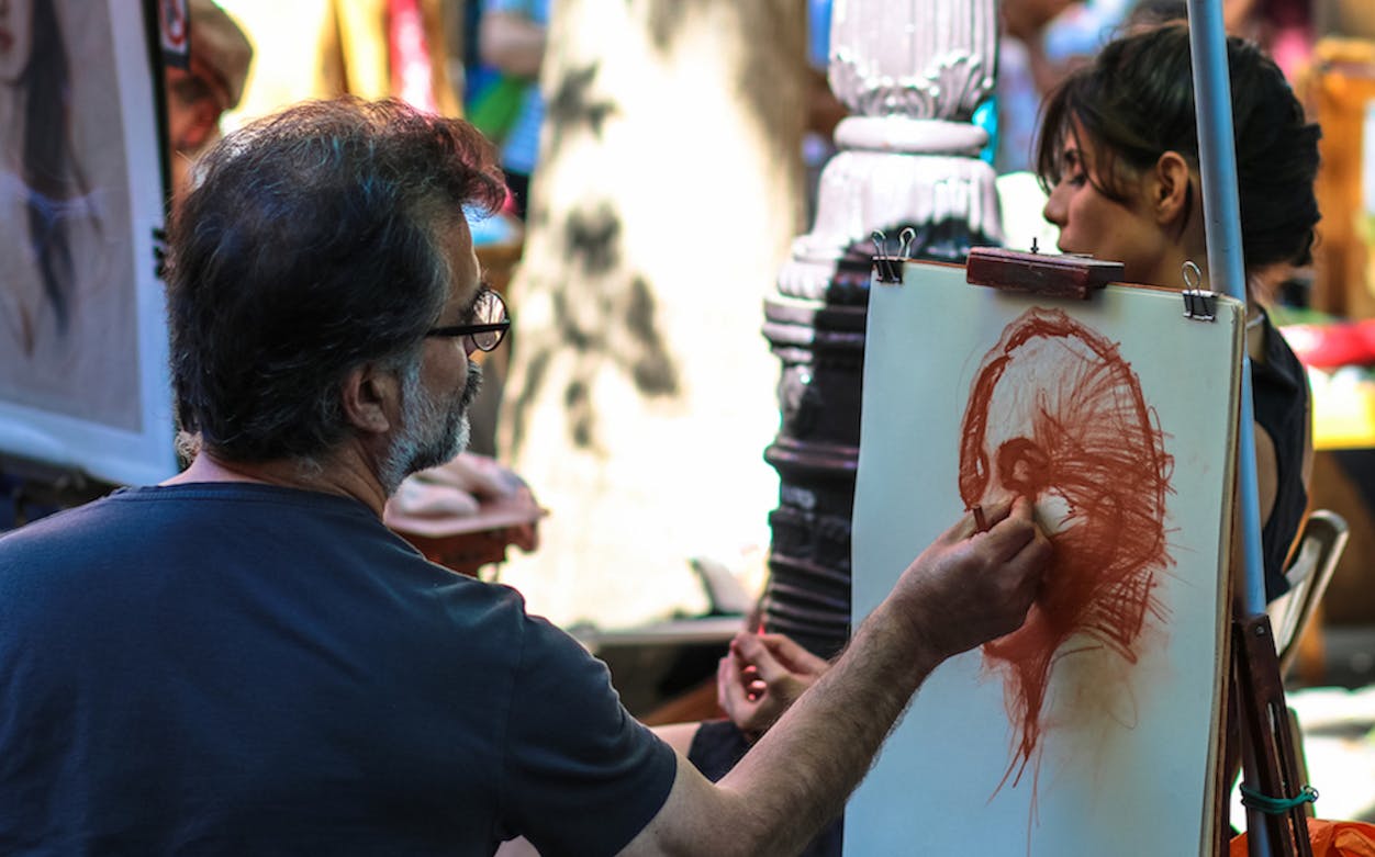 Montmartre street scene with artists painting near Sacré-Cœur Basilica, Paris.