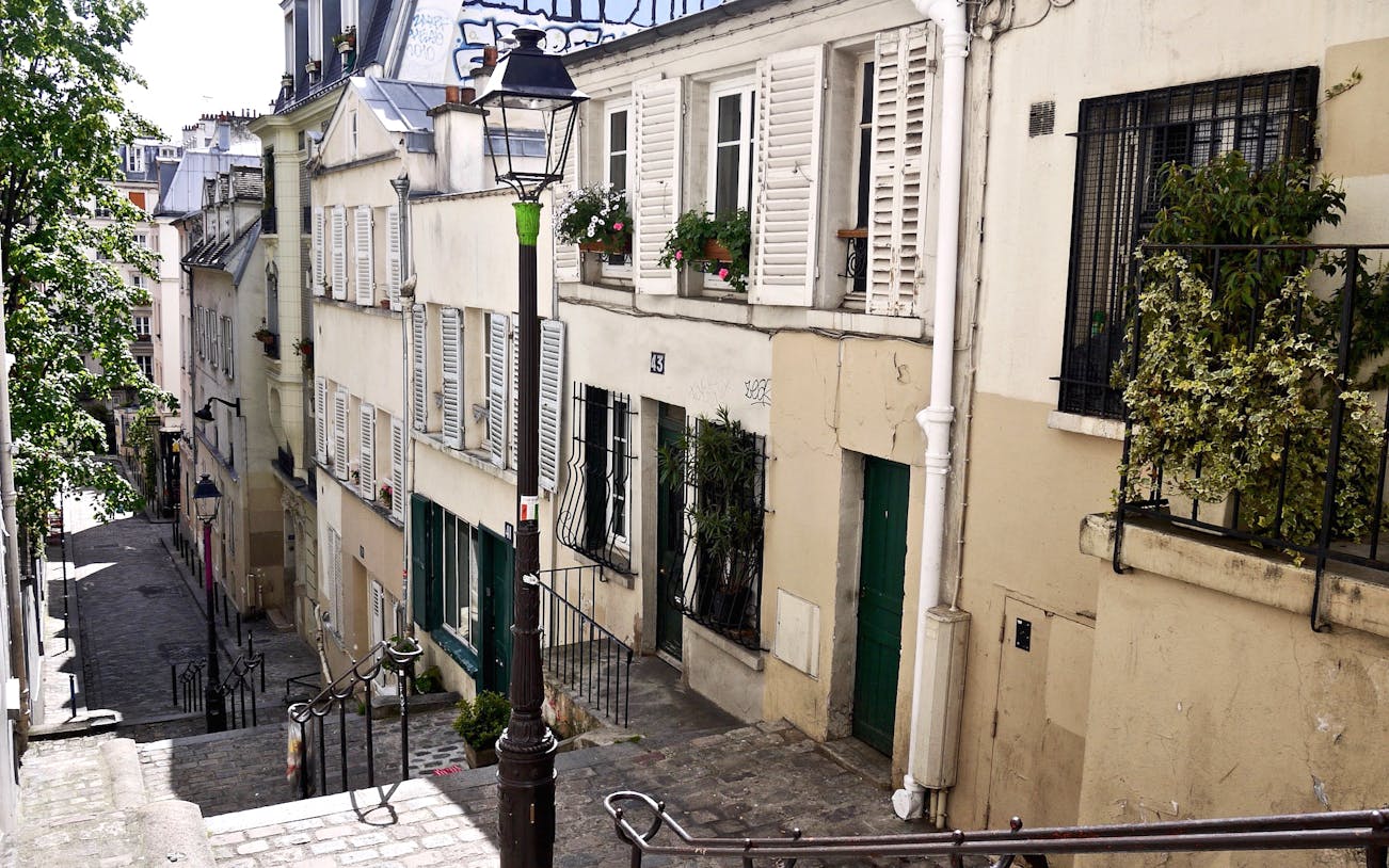 Montmartre steps with artists and tourists in Paris' vibrant quarter.