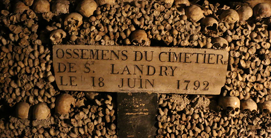 Paris Catacombs wall of bones with St. Landry Cemetery sign dated June 18, 1792.