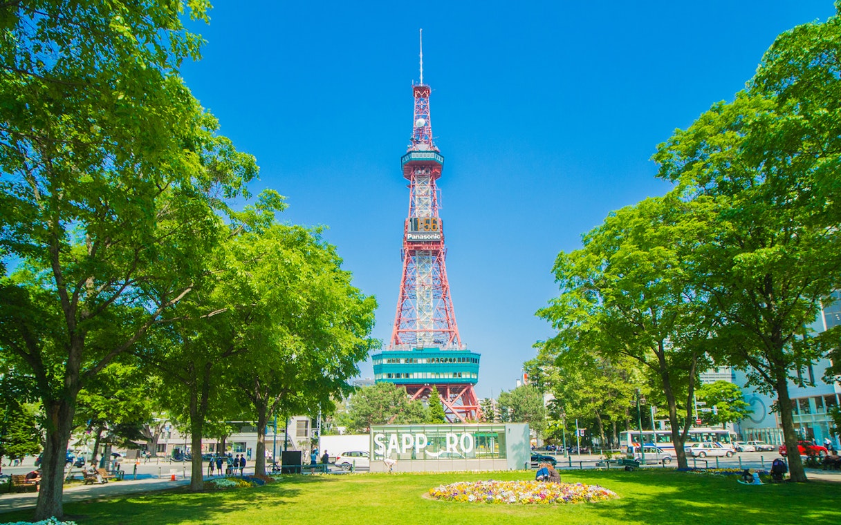 Sapporo TV Tower surrounded by trees and a park in Sapporo, Japan.