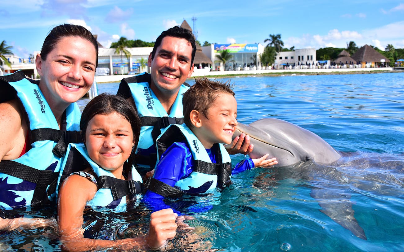 Family enjoying a dolphin encounter in Tulum, Mexico.