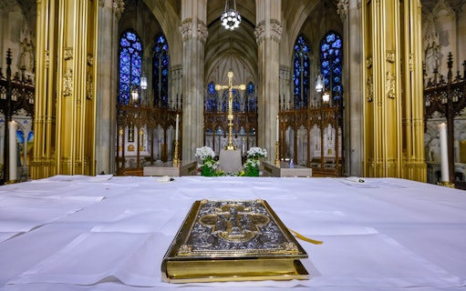 St. Patrick's Cathedral altar with ornate book and stained glass windows.