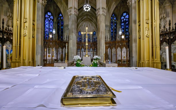 St. Patrick's Cathedral altar with ornate book and stained glass windows.